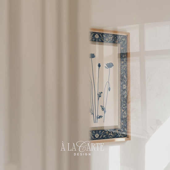 Printable wall art featuring a blue-gray botanical poppy illustration with seed pods and leaves, centered on a cream background with an ornate dark blue floral border.
